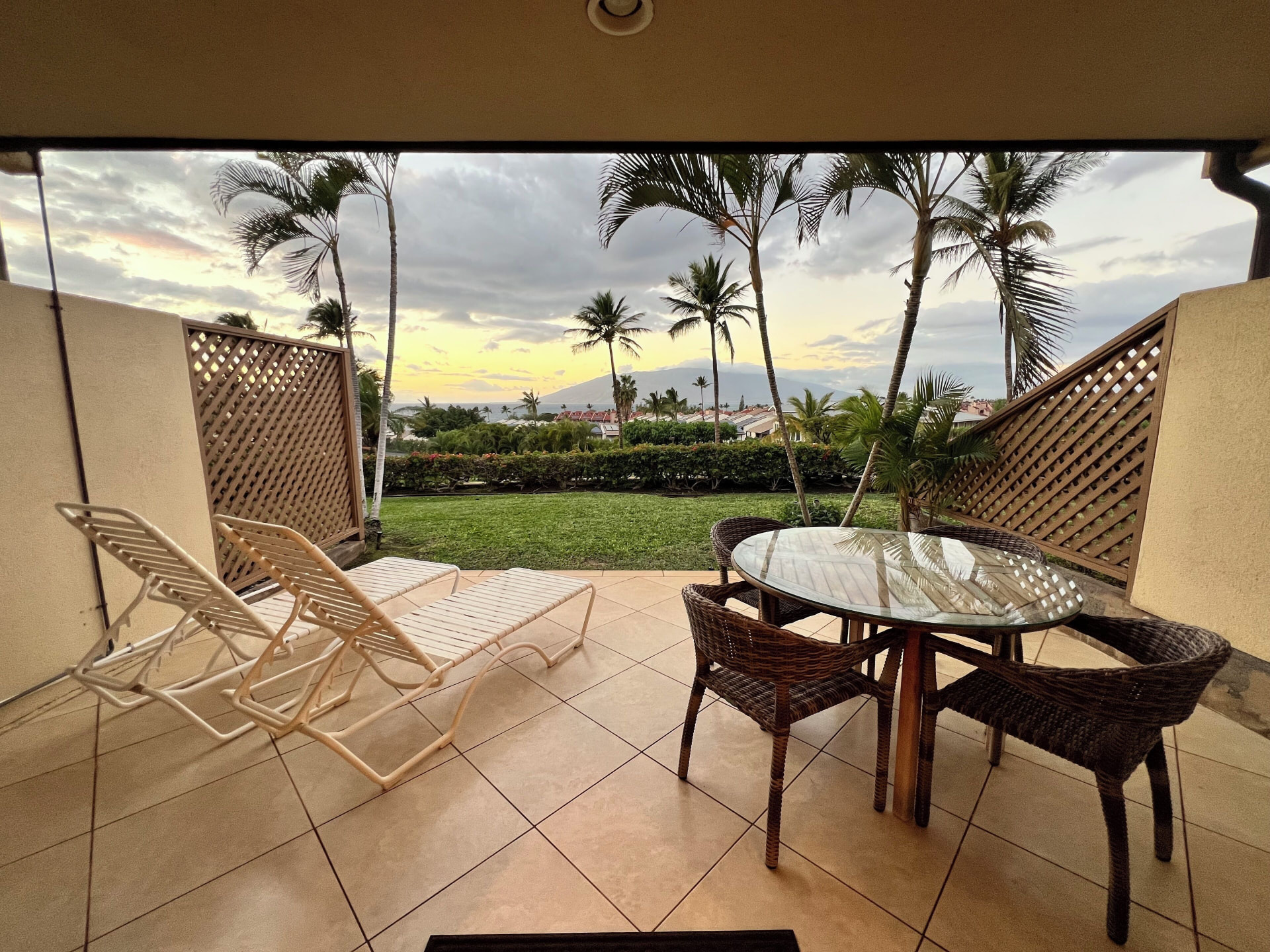 Private lanai with loungers and dining table at dusk